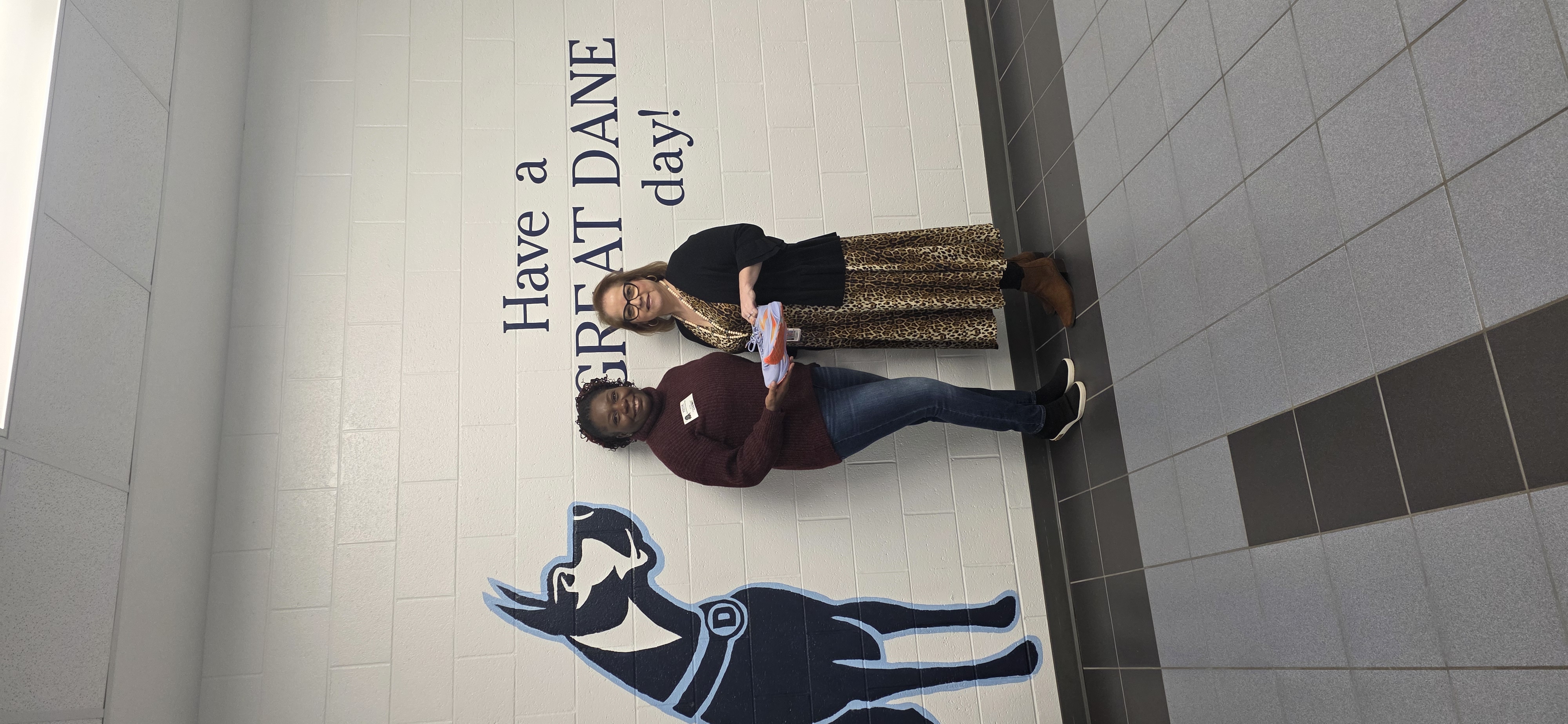 GSF representative presenting a donated shoe to a Denmark High School staff member