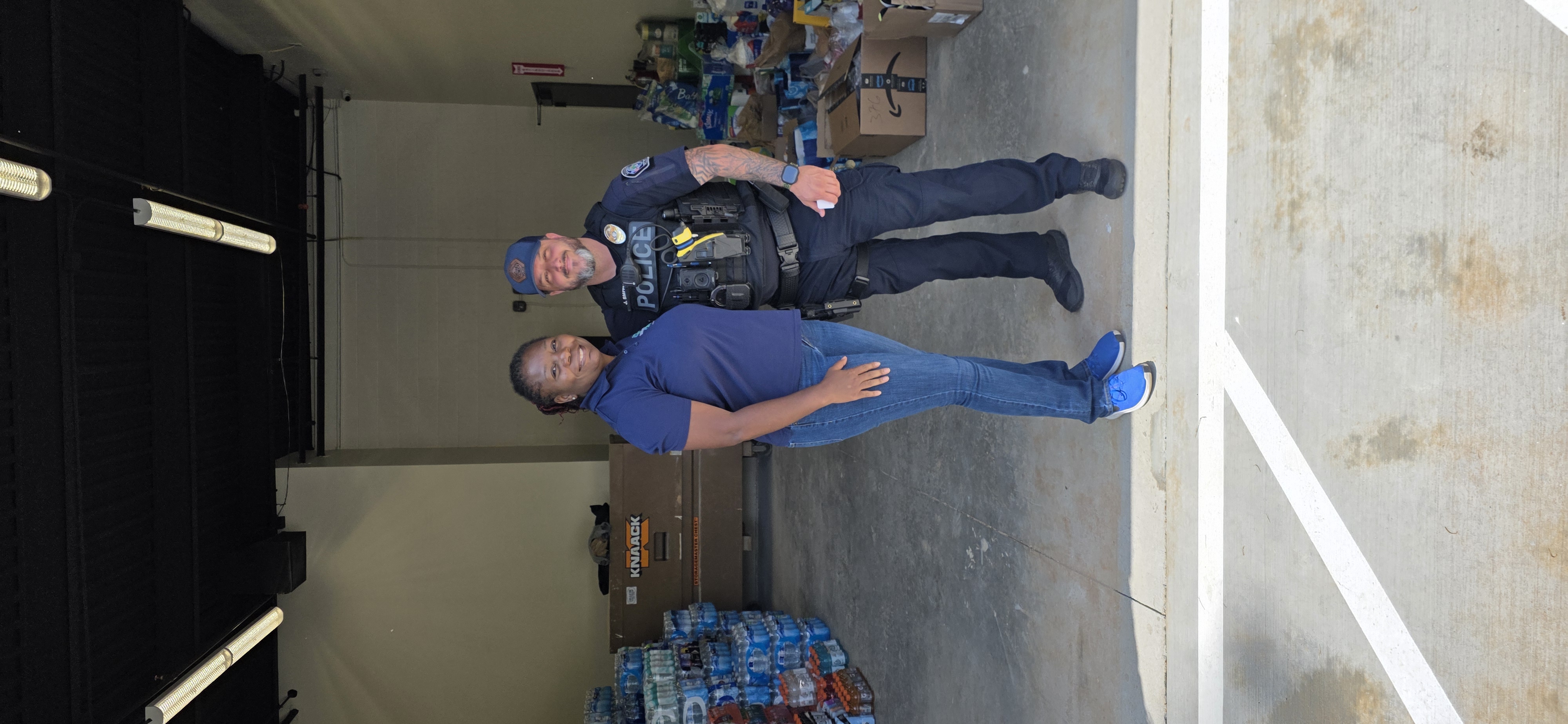 Grounded Soles Foundation representative with police officer surrounded by donated relief supplies for South Georgia firefighters